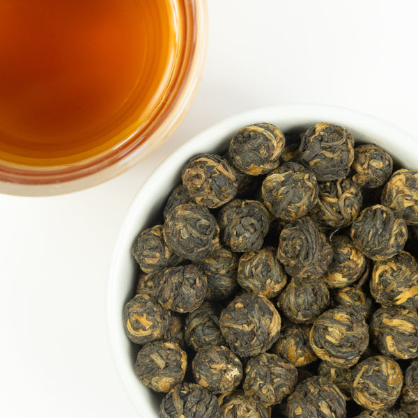 Black Dragon Pearls tea, brewed and loose leaf.