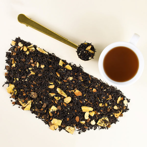 Cup of Celebration tea next to mound of Celebration loose leaf tea.