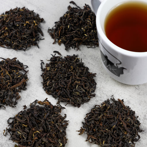 Cup of Darjeeling Oolong tea next to mounds of Dajreeling Oolong loose leaf tea.