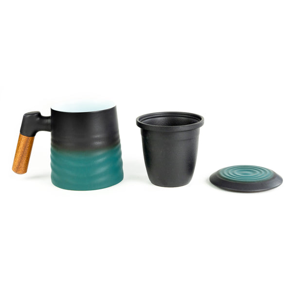 A Whistling Kettle Wave Mug next to its infuser and lid