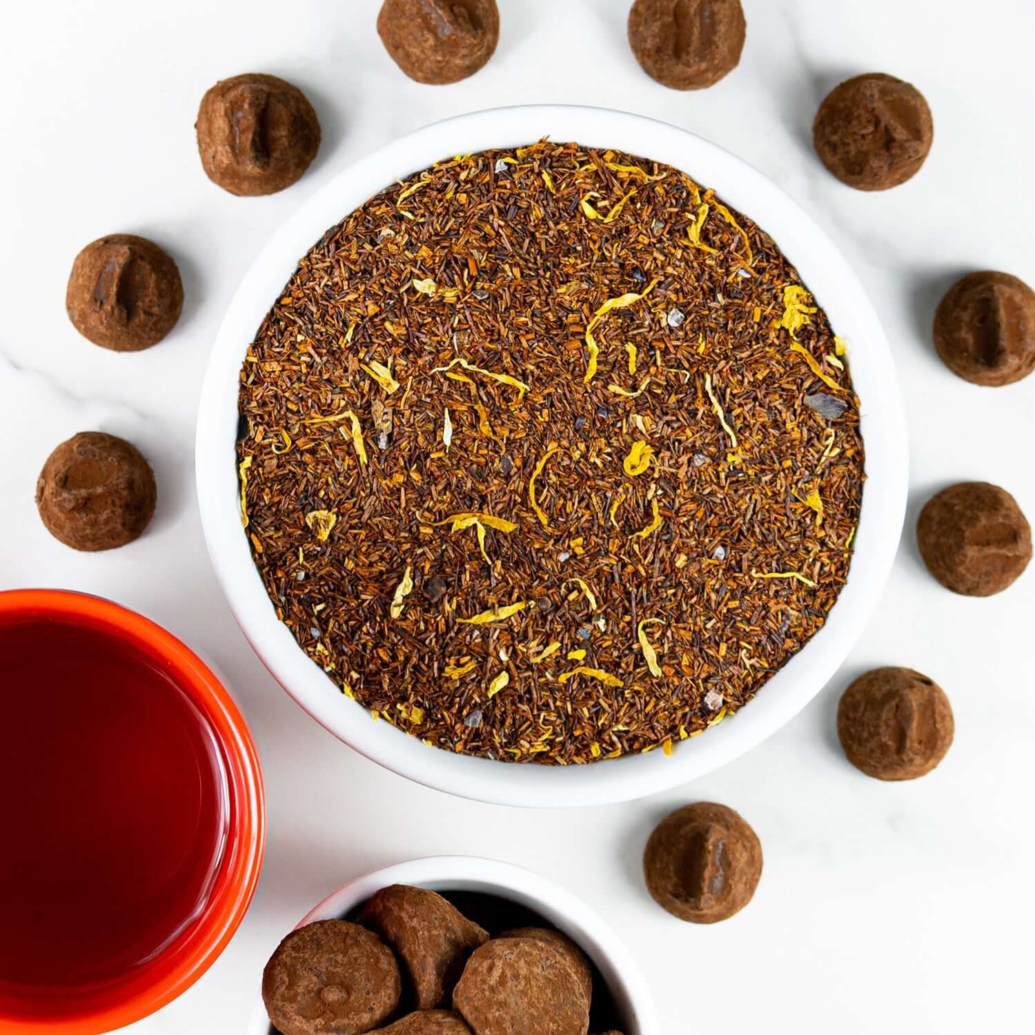 A Bowl of Pumpkin Cheesecake tea next to a slice of Pumpkin Cheesecake dessert.