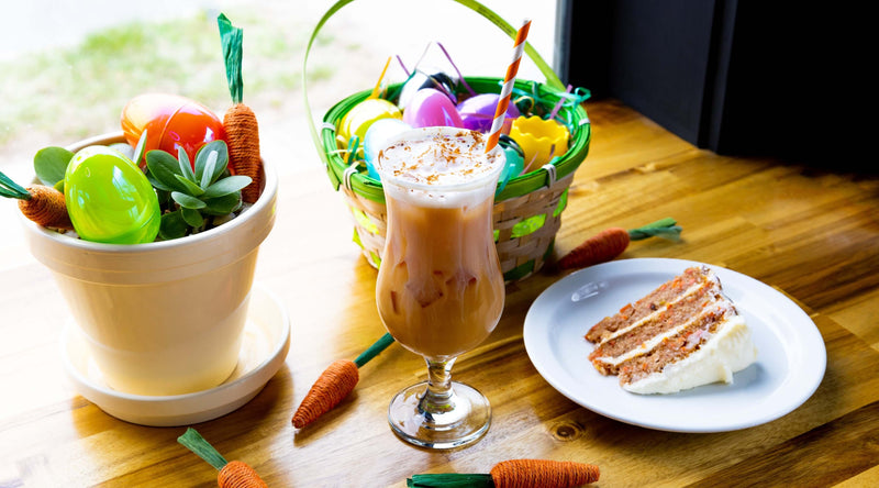 Carrot cake latte next to slice of carrot cake easter decorations