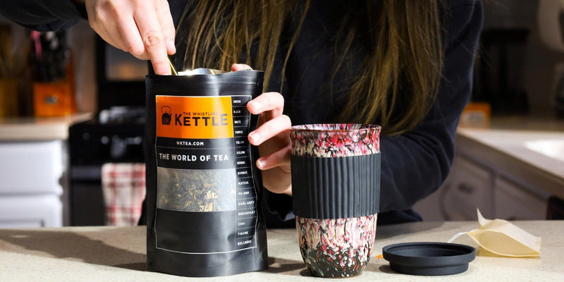 A tea pot pouring tea in to cups 