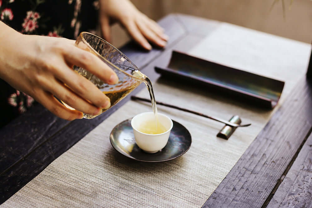 A glass of oolong tea being poured