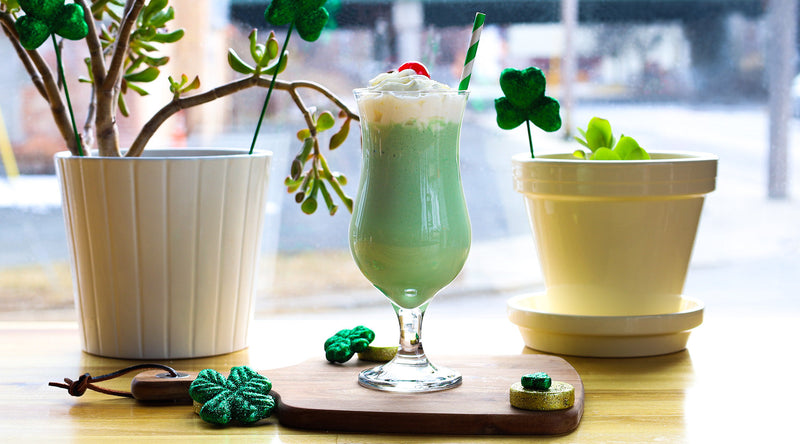 Matcha shamrock shake on cutting board with shamrock decoration