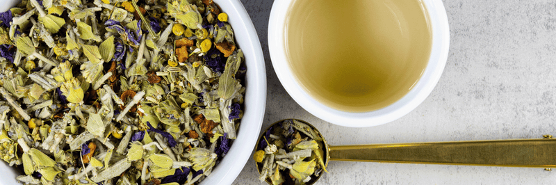 Greek Mountain Meadow tea in a bowl next to a cup of brewed tea