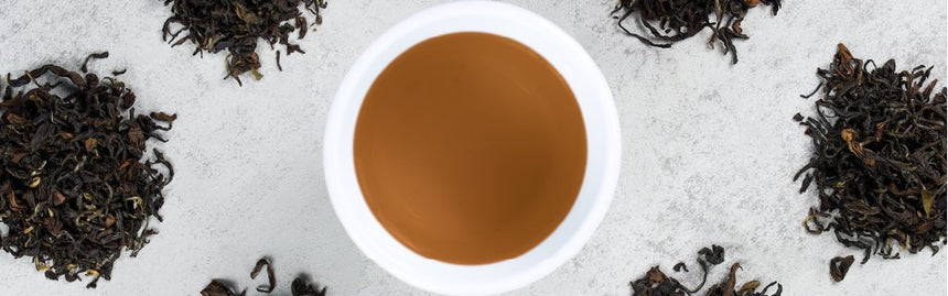 Piles of tea leaves surround a tea cup