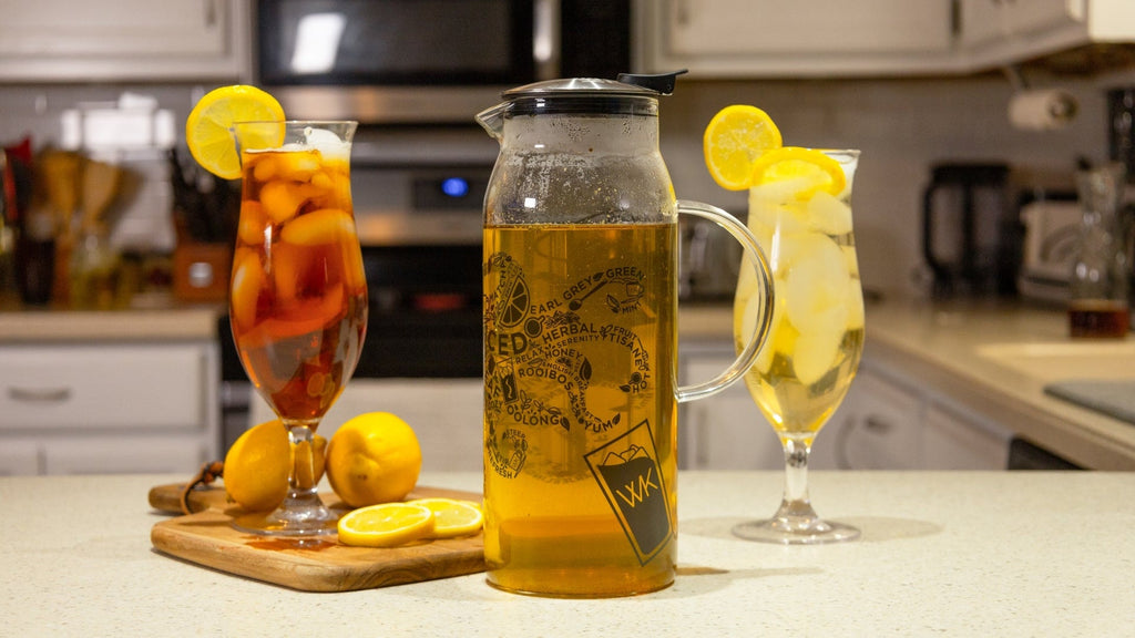 Decisive Iced Tea Brewer filled with iced tea, two glasses of iced tea with lemons