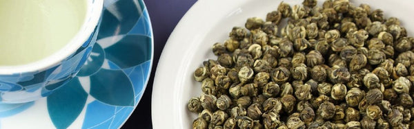 pure loose leaf green tea next to a tea cup