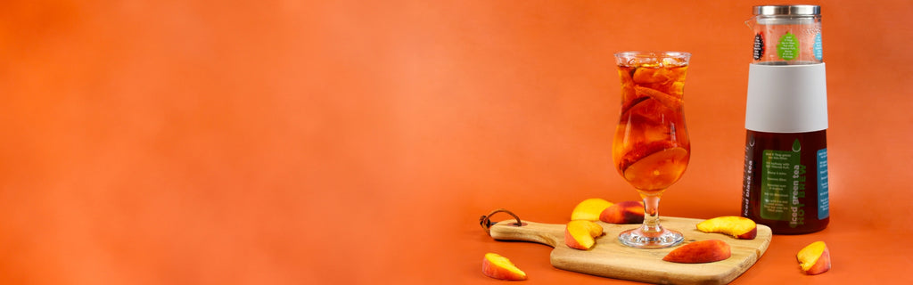 Peach iced tea on a cutting board with fresh peach slices