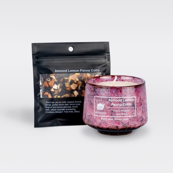 A  pink and black marbled teacup filled with wax and wick is next to a black resealable pouch of loose-leaf tea. Both items are labeled as “Almond Lemon Panna Cotta.”