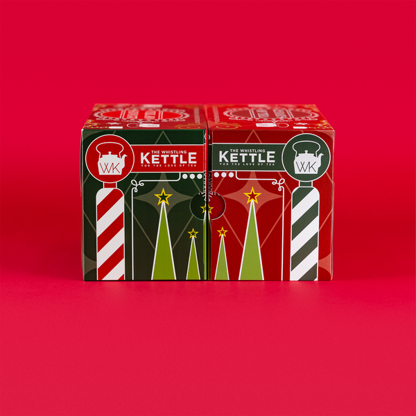 Two festive 12 Days of Tea advent calendar boxes sit side by side against a bright red background with red, green, and white holiday designs