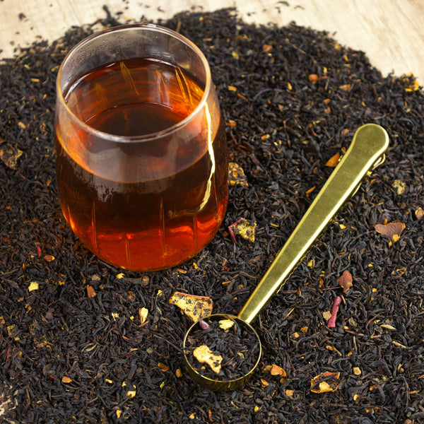 Glass of Apple Cider Donut tea on top of Apple Cider Donut tea leaves.