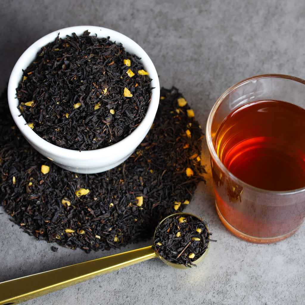 Glass of Autumn Haze tea next to bowl of Autumn Haze tea leaves.