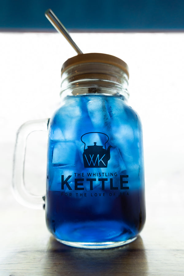 Iced Butterfly Pea Flower tea with a brilliant sapphire-blue hue, served over ice in a mason jar