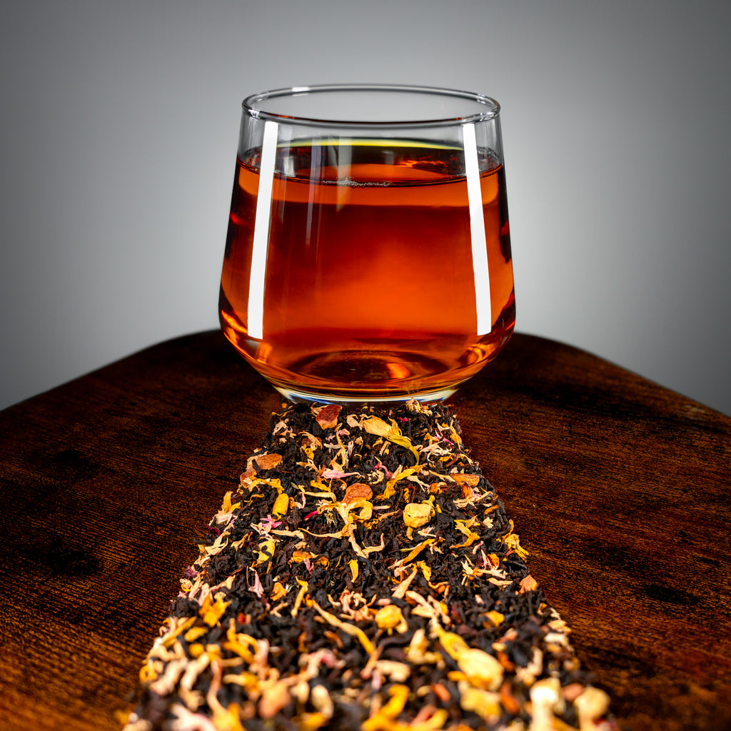 Close-up view of amber Caramel Toffee tea with loose tea and petals