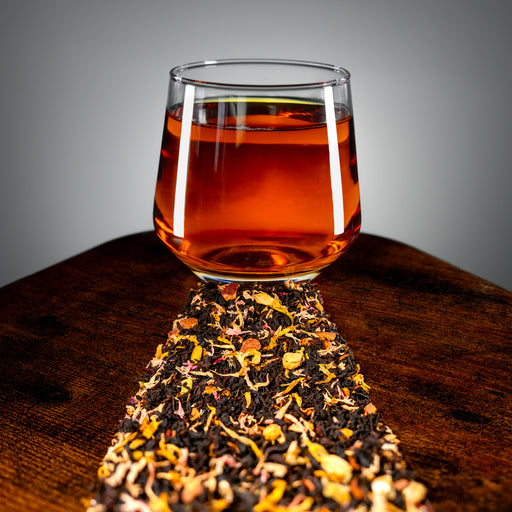 Close-up view of amber Caramel Toffee tea with loose tea and petals