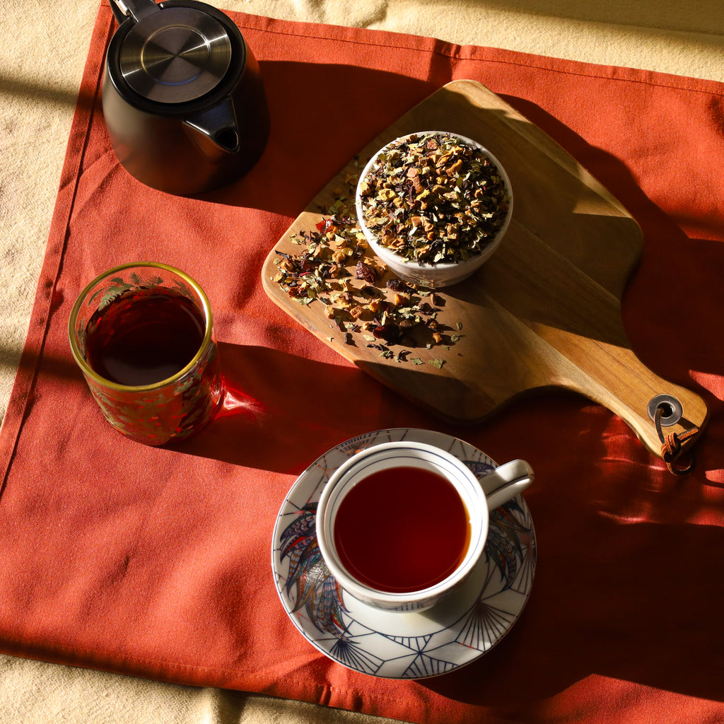 Cups of Cleanse tea next to Black Nordic Tea Pot and bowl of Cleanse tea leaves.