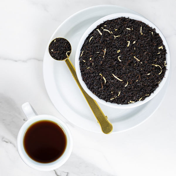 Cup of brewed Coconut tea next to bowl of loose leaf Coconut tea.