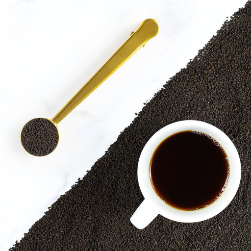 Cup of Kambaa tea on top of mound of Kambaa loose leaf tea.