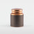 A cylindrical stainless steel tea tin with a textured black label and a shiny rose-gold lid