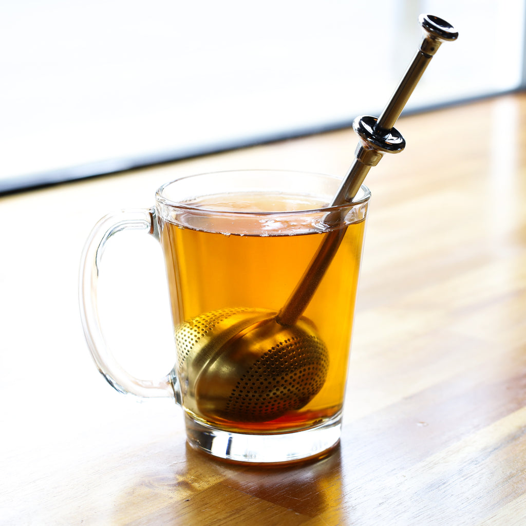 The Whistling Kettle Lil' Springer Long Handle Tea Ball Infuser in cup.