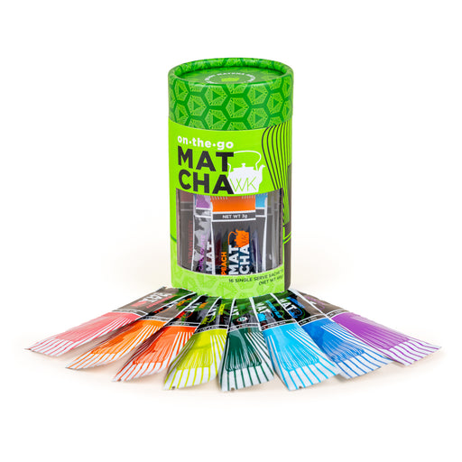 A green cylindrical package of on-the-go matcha sachets, with several individual colorful packets fanned out in front on a white background