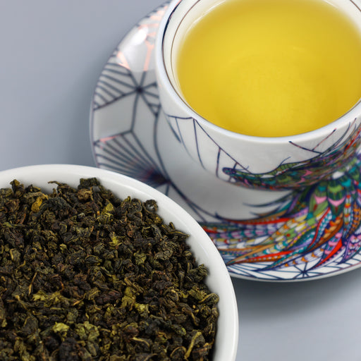 Cup of Milk Oolong next to bowl of Milk Oolong loose leaf tea.