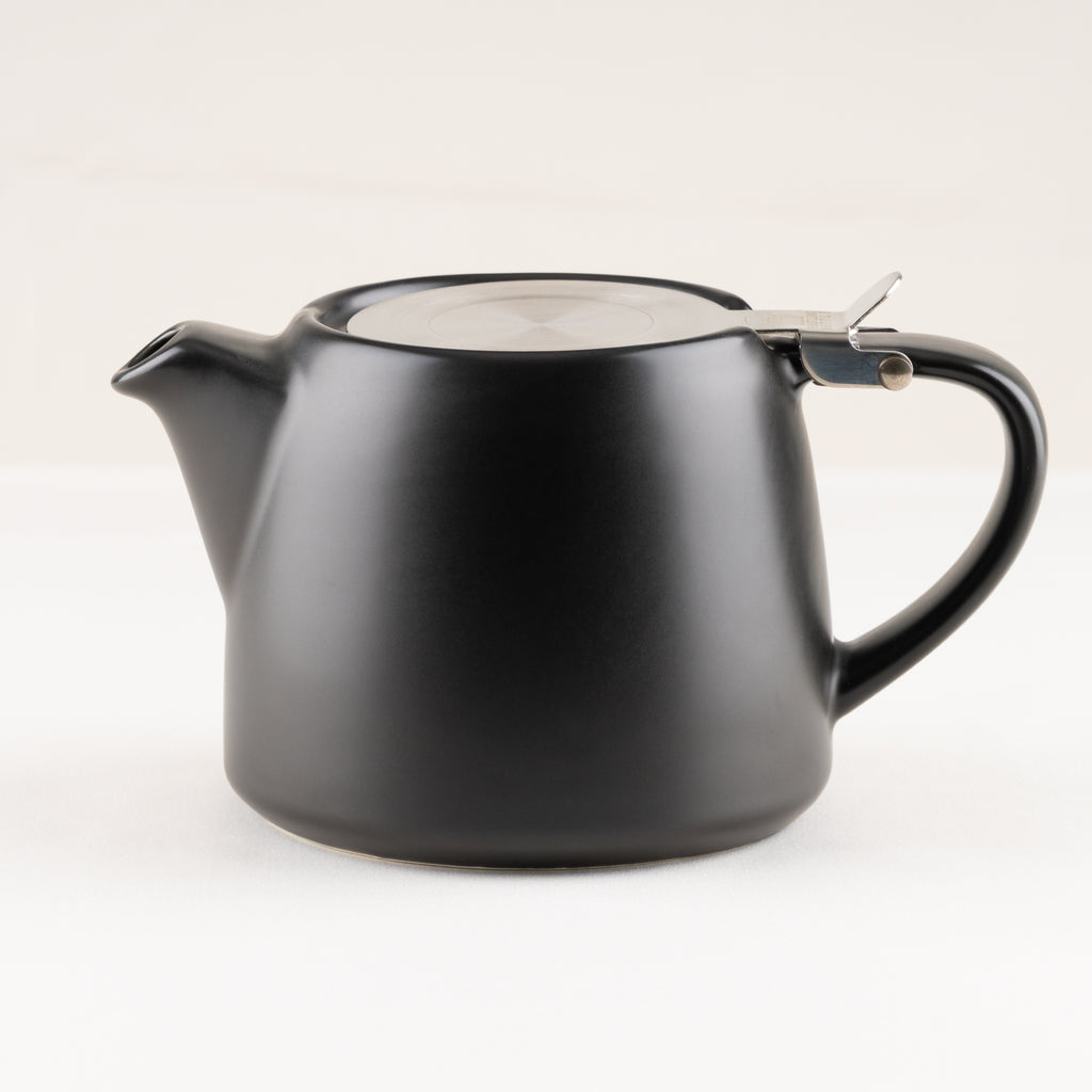Black teapot with a lid on a white background.