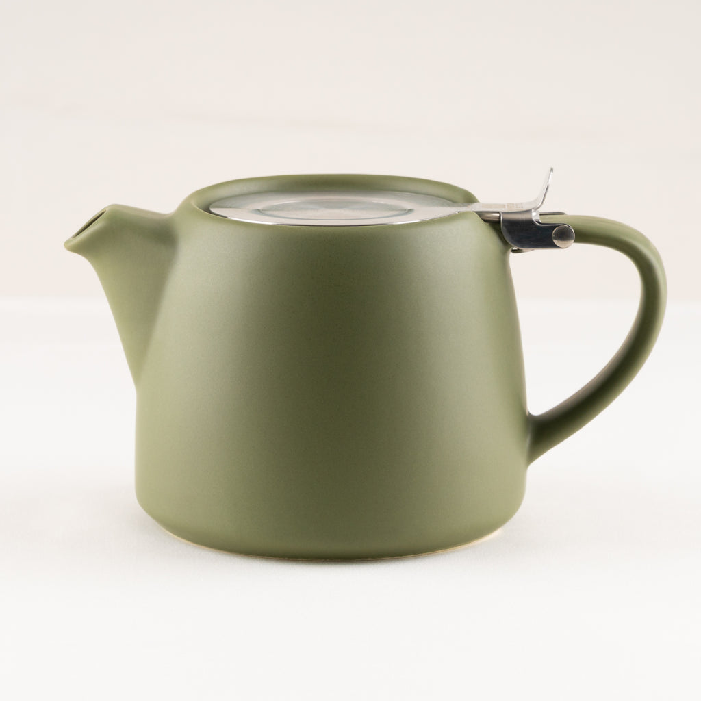 Green teapot with a clear lid on a white background.
