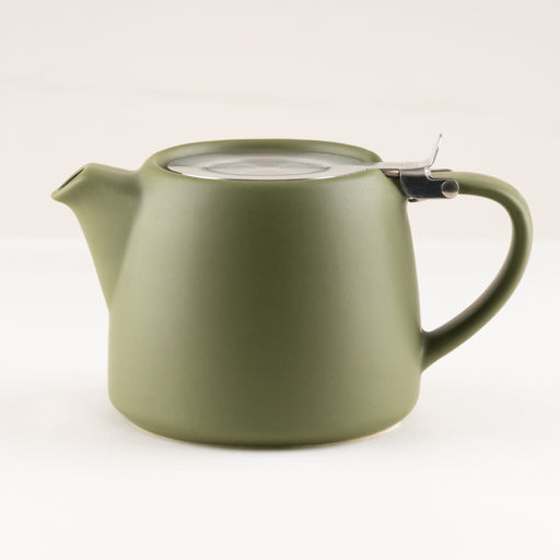 Green teapot with a clear lid on a white background.