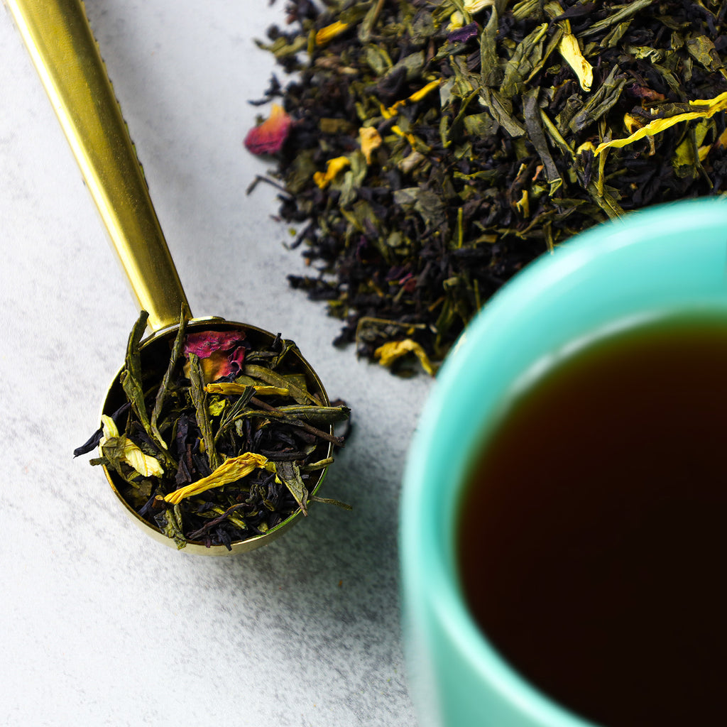 Peach Rose tea in cup next to mound of Peach Rose loose leaf tea.