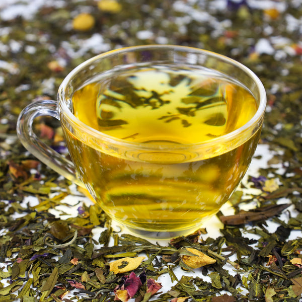 Glass of brewed Shaolin's Grove surrounded by Shaolin's Grove loose leaf tea.