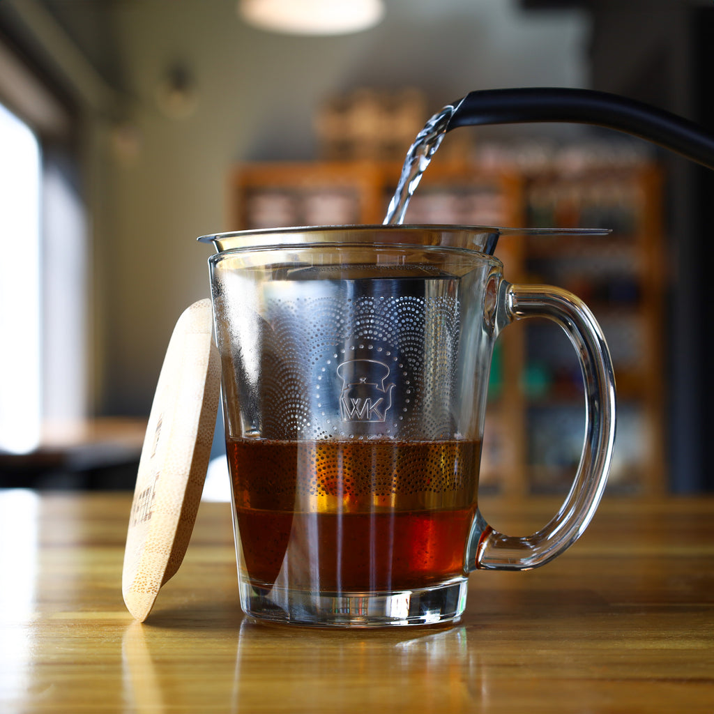 The Whistling Kettle "The Steepster" Stainless Steel Tea Infuser with Bamboo Top in cup.