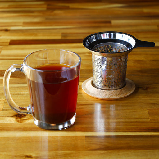 The Whistling Kettle "The Steepster" Stainless Steel Tea Infuser with Bamboo Top in cup.