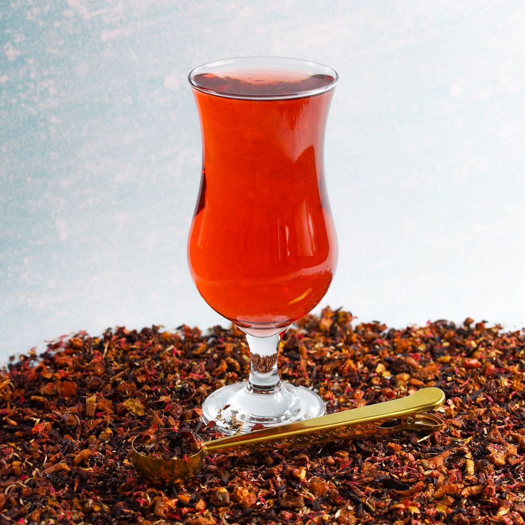 Glass of Strawberry Watermelon on top of Strawberry Watermelon tea leaves.