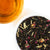 Sweet Strawberry loose leaf tea in an overhead shot with infusion of tea in glass cup