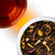 Overhead shoot of Taffy Apple loose next to a deep brown cup of tea on a white background. 