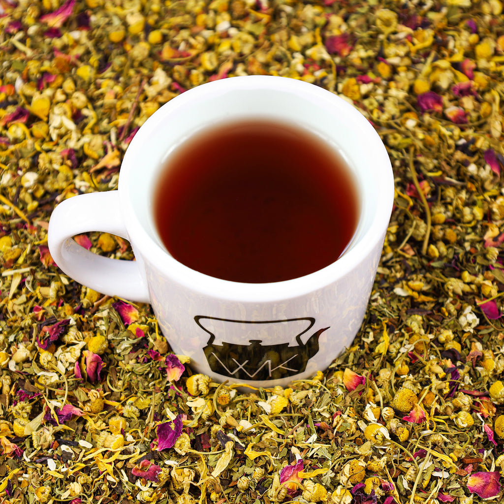 Cup of Total Body tea in the middle of mound of Total Body tea leaves.