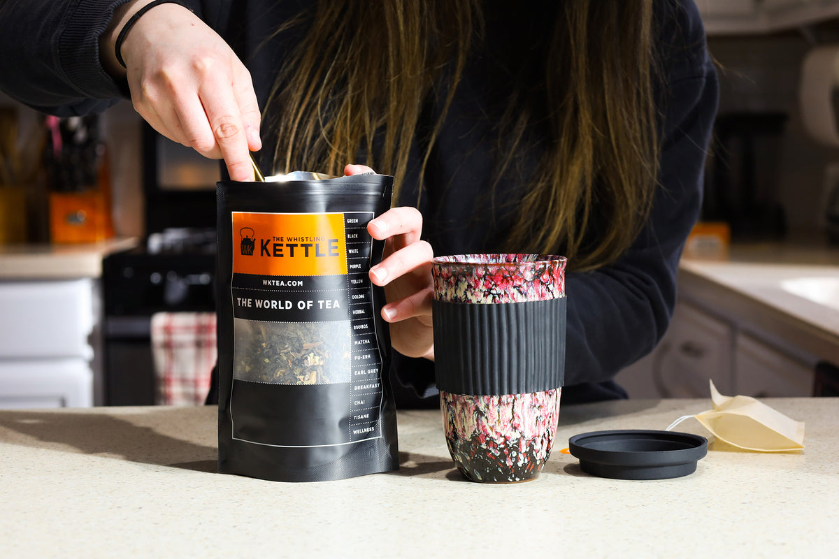A woman scoops tea from a bag