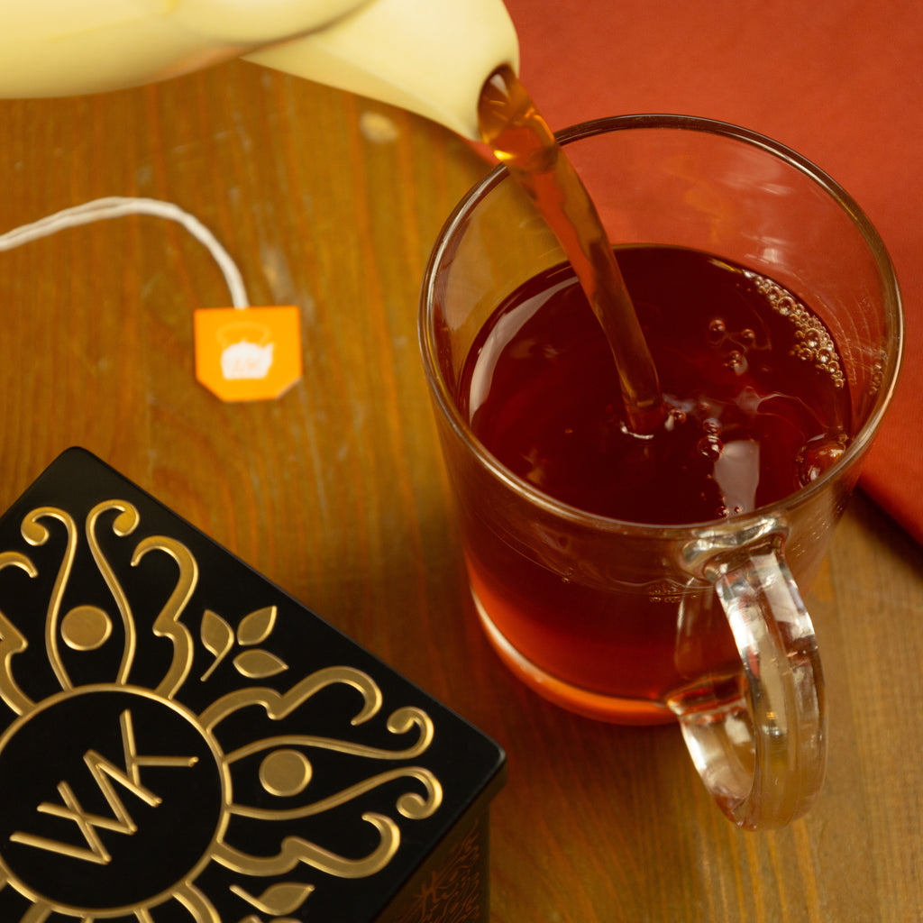 Brewed Vanilla Rooibos tea being poured into glass.