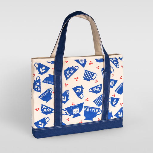 Cream and navy canvas tote bag featuring a blue teacup pattern, reinforced handles, and coordinating navy trim