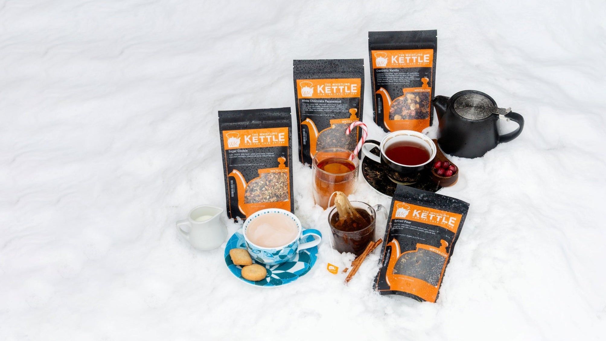spiced pear, sugar cookie, cranberry vanilla, and white chocolate peppermint winter teas in snow