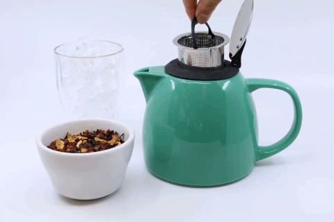 Brief gif of a hand removing the infuser inside a turquoise ceramic teapot, placing tea leaves into the infuser, resetting the infuser into the teapot, pouring boiling water, then pouring red tea from the teapot into an iced glass