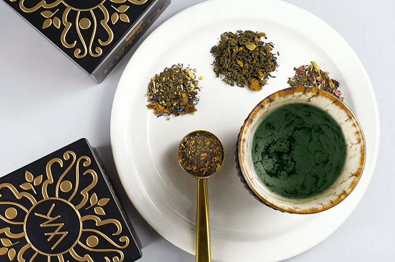Piles of hemp tea sit on a plate next to a cup of brewed tea