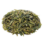 Side mound picture of The Whistling Kettle Dragonwell Lung Ching green tea with long vibrant leaves.