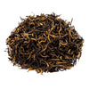 Side mound photo of The Whistling Kettle Golden Monkey black tea leaves with golden tips.